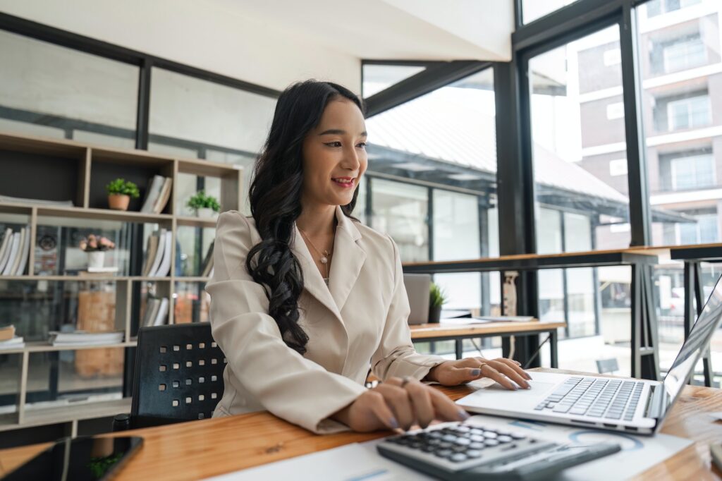 Accountant woman working with calculator and laptop computer, Tax deduction planning concept