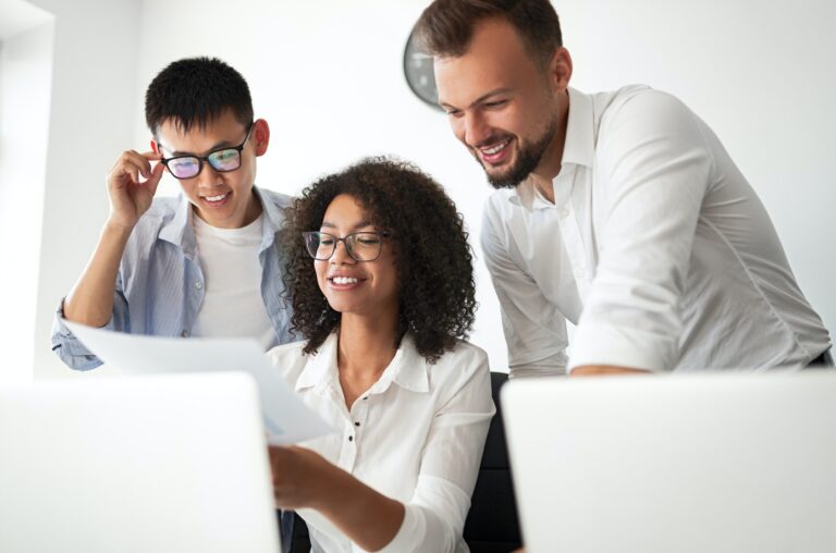 Optimistic diverse colleagues discussing document in office